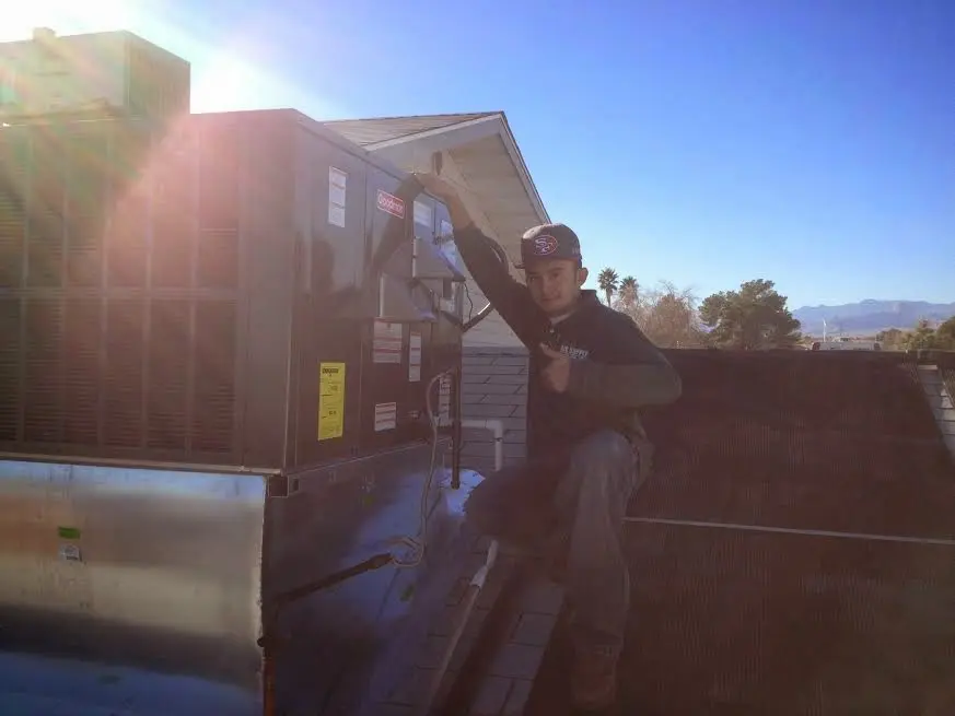 HVAC technician performing Boiler Repair on a rooftop unit in New Burlington